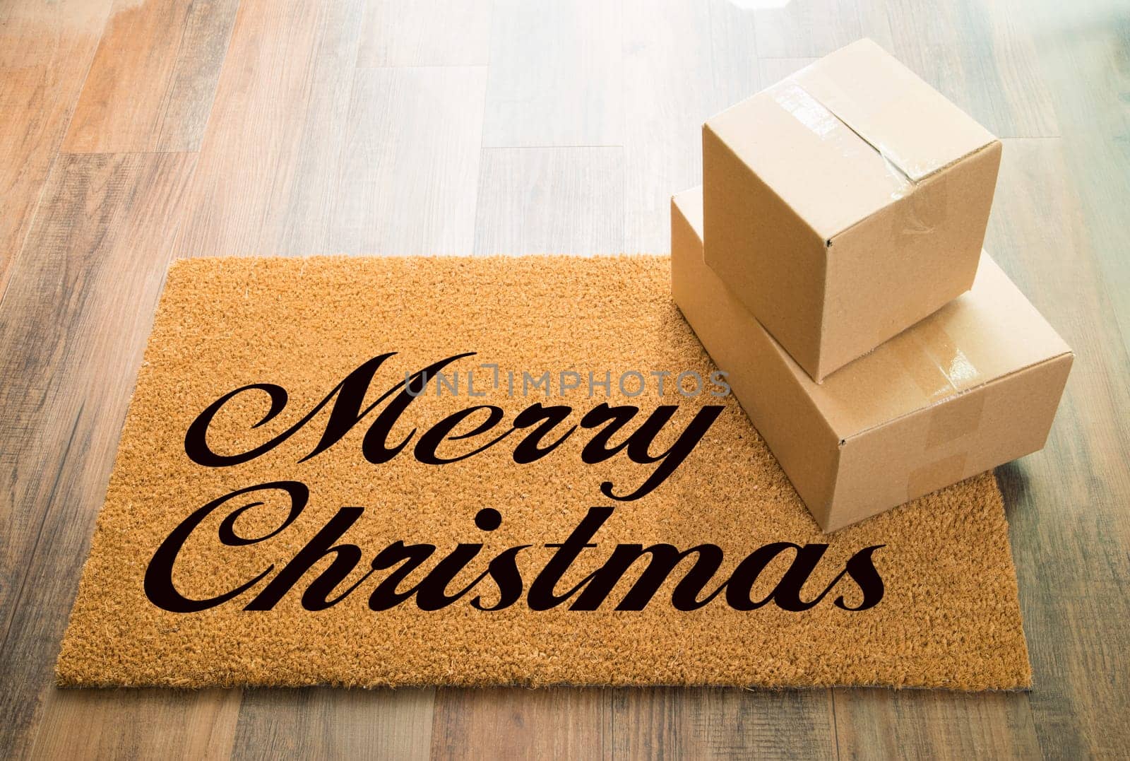 Merry Christmas Welcome Mat On Wood Floor With Shipment of Boxes.