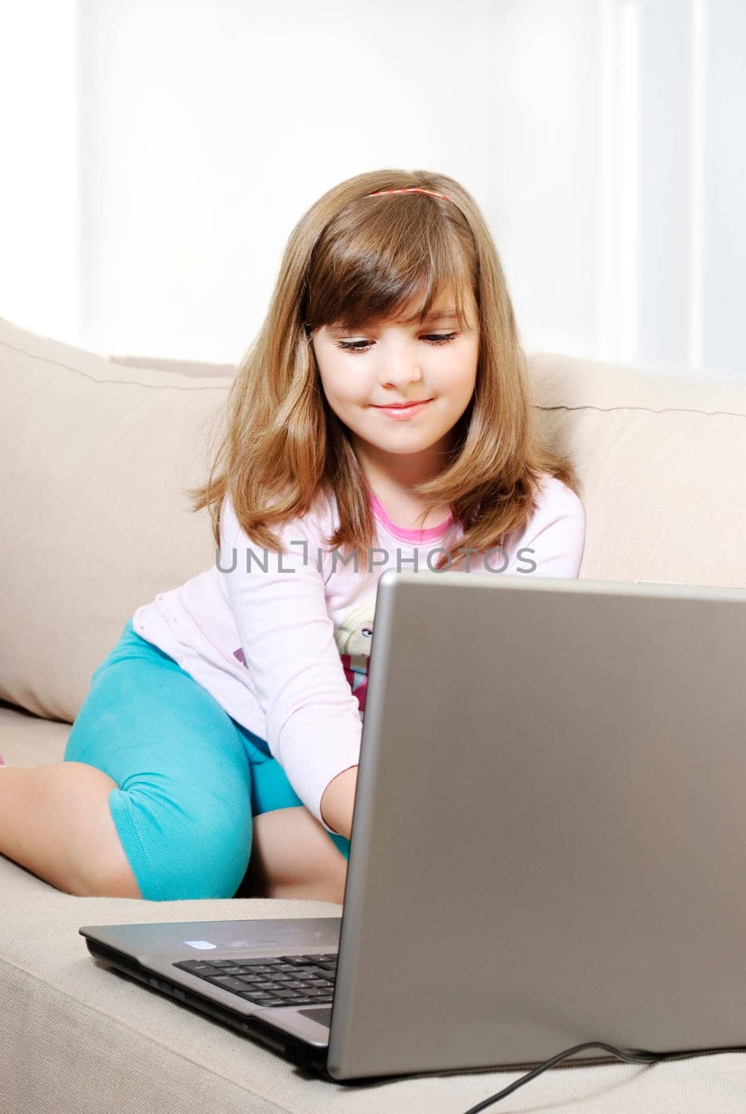 Beautiful happy little girl with laptop