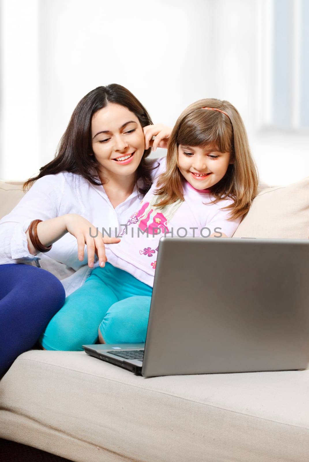 Mother and daughter looking at laptop and smiling