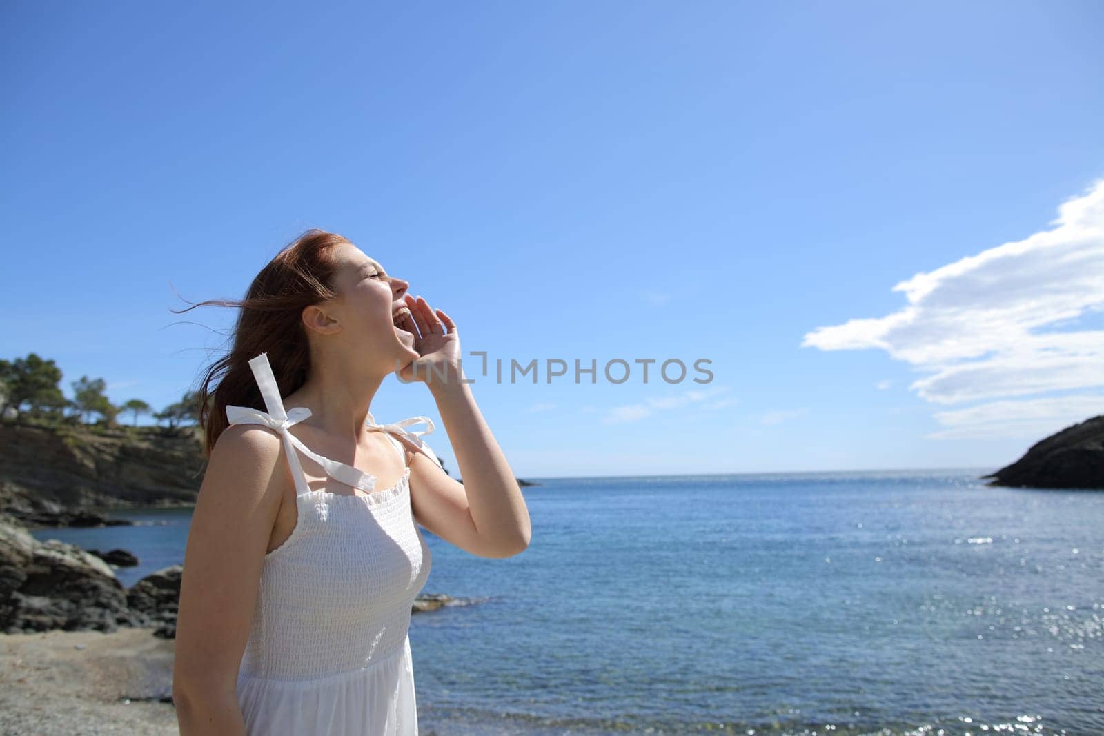 Happy woman in white screaming on the beach