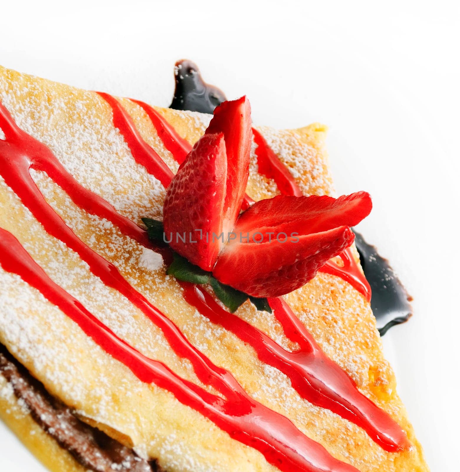 Decorative pancake with strawberry and chocolate syrup