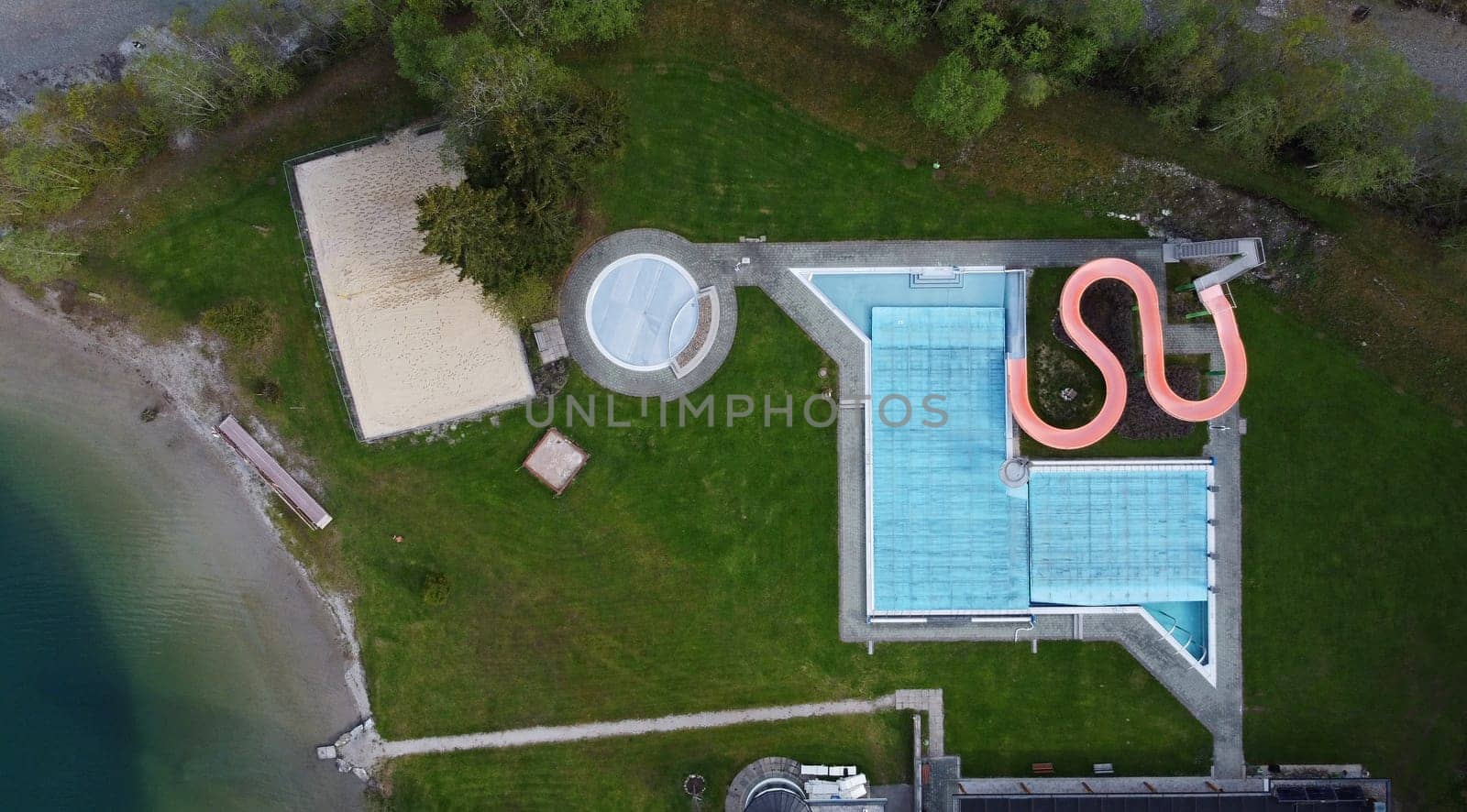Aerial view with drone of closed outdoor swimming pool with slide