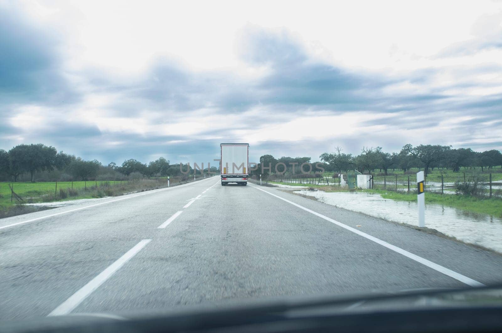 Driving behind a truck under persistent drizzle. Bad-weather driving concept