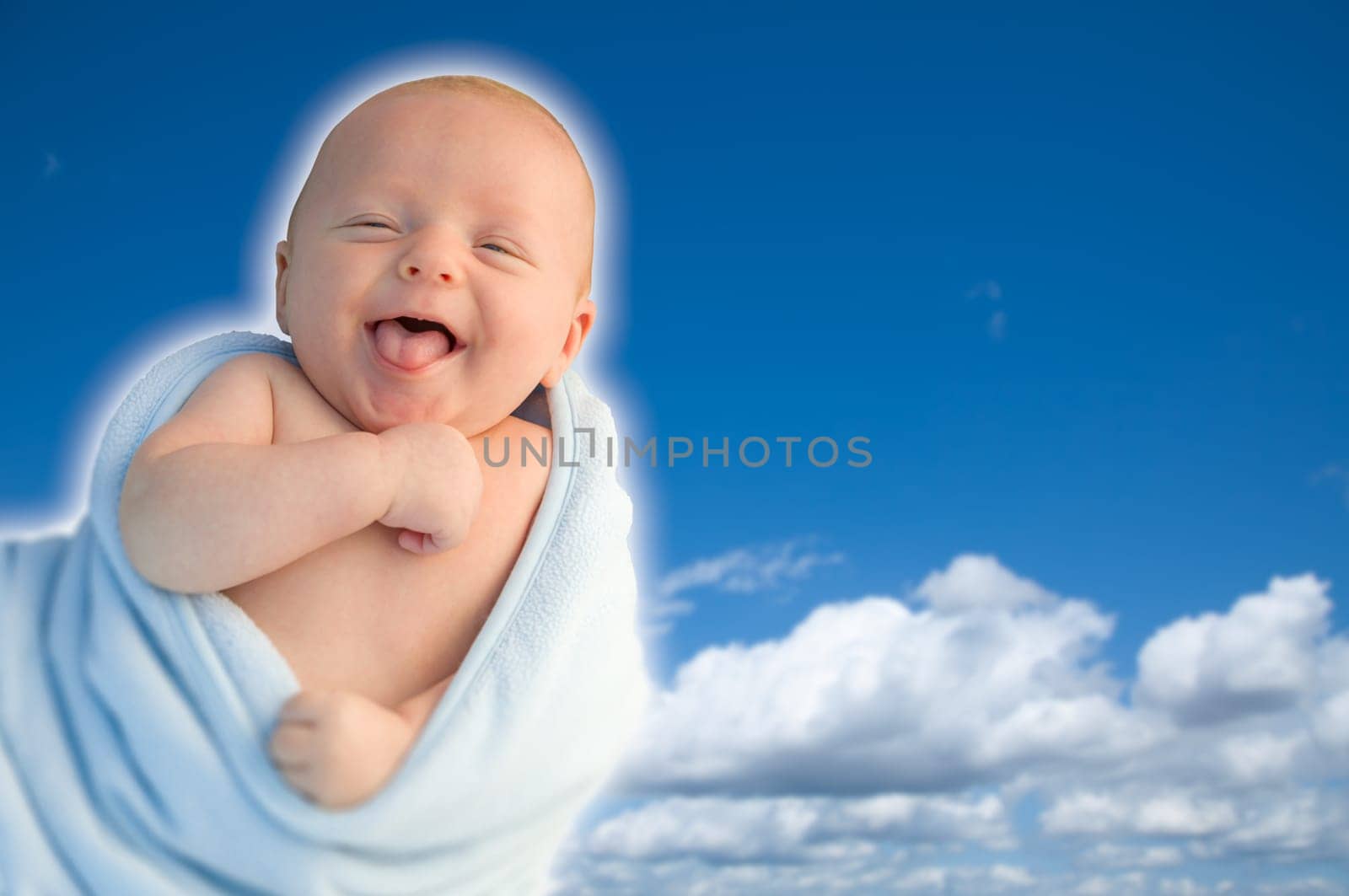 Beautiful Laughing Baby Boy Wrapped in His Blanket With A Blue Sky Background.