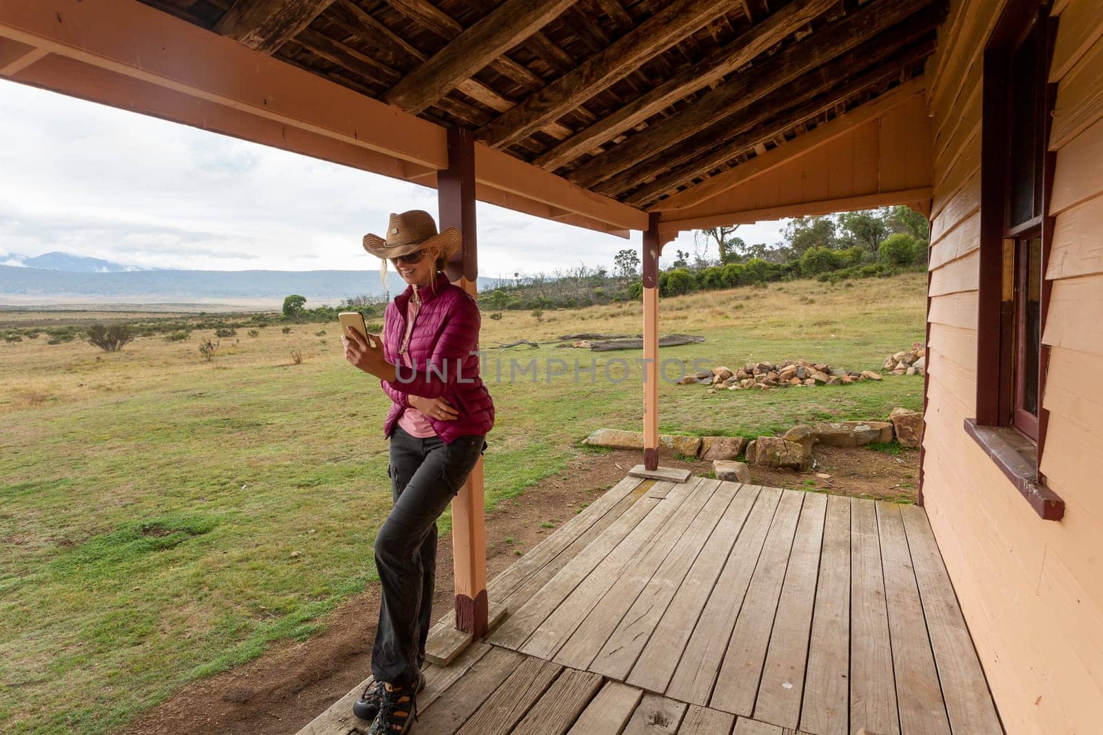 Country woman using her mobile phone in a rural farmland setting