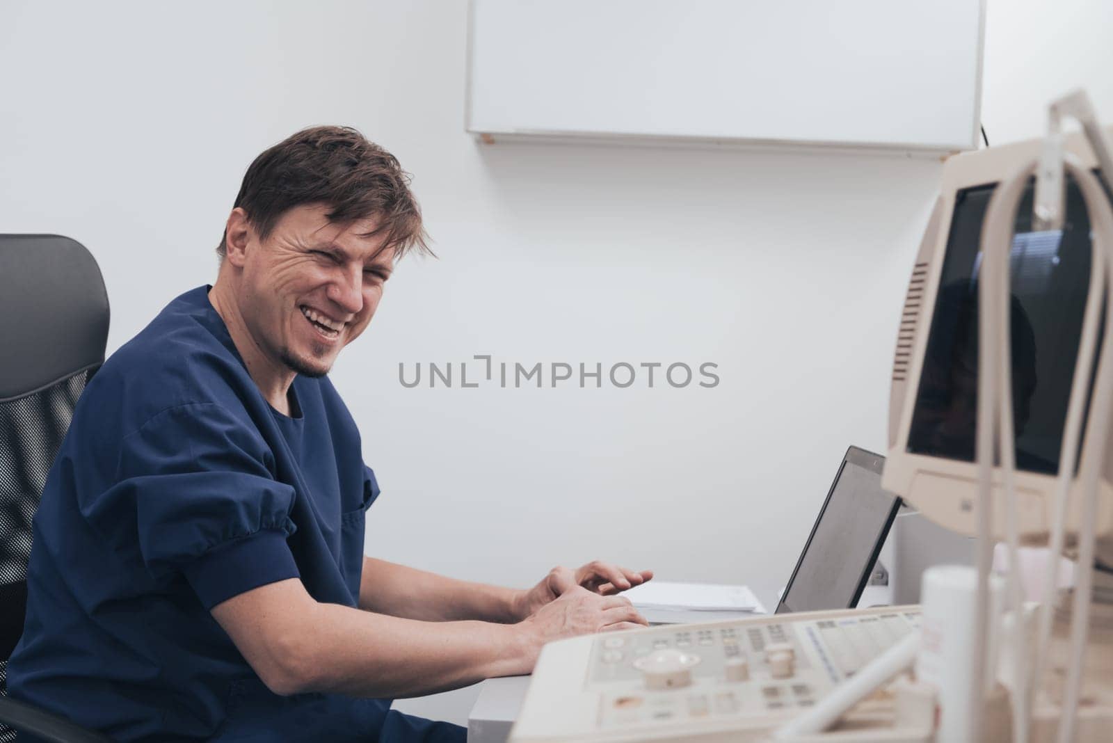 Orthopedist doctor examining X-ray picture at a desk in clinic on a laptop computer. High quality photo. Selective focus