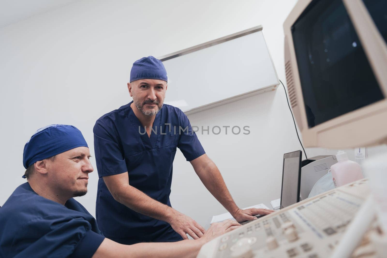 Orthopedist doctor team examining digital X-ray picture in clinic on a laptop computer. High quality photo. Selective focus