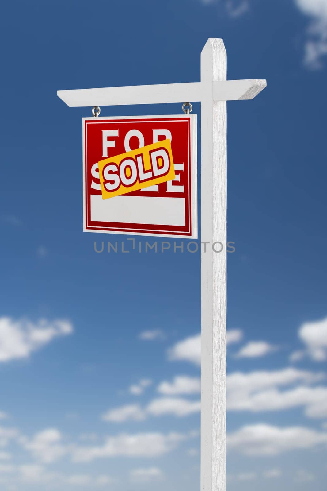 Left Facing Sold For Sale Real Estate Sign on a Blue Sky with Clouds.