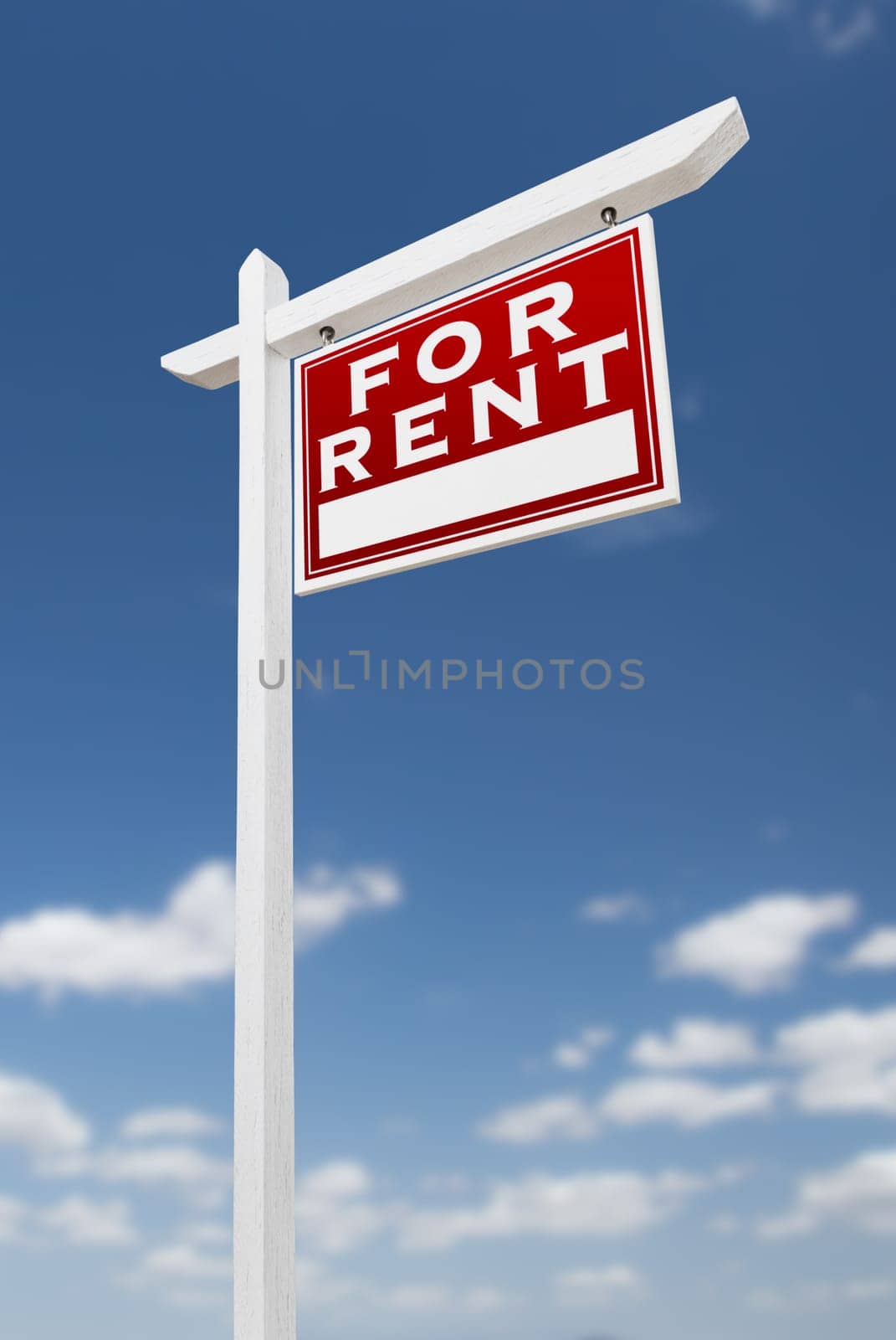Right Facing For Rent Real Estate Sign on a Blue Sky with Clouds.