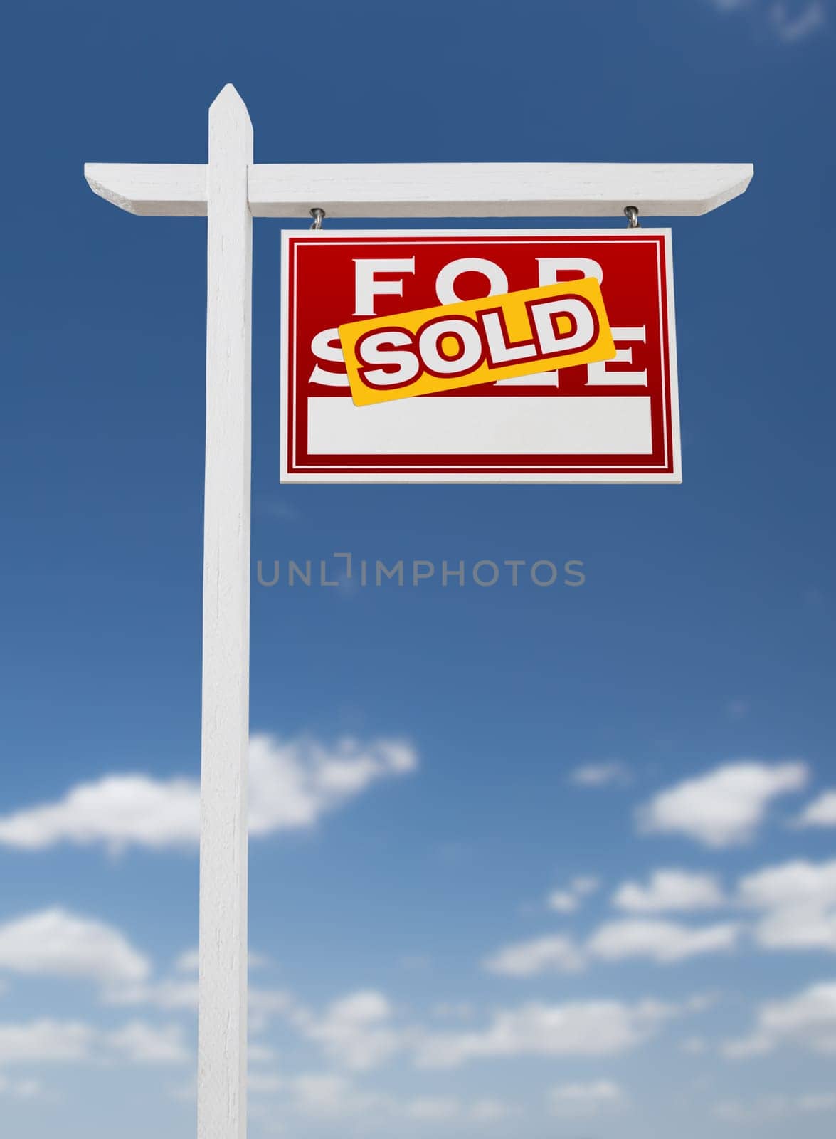 Right Facing Sold For Sale Real Estate Sign on a Blue Sky with Clouds.