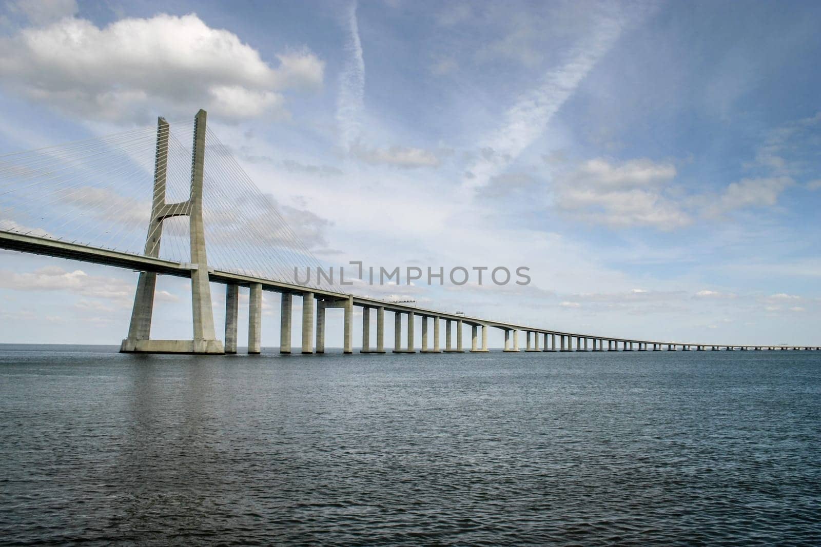 Lisbon, Portugal - September 18, 2006:  Vasco da Gama Bridge over Tagus River with dramatic clouds in background. Bridge was opened for Expo 98