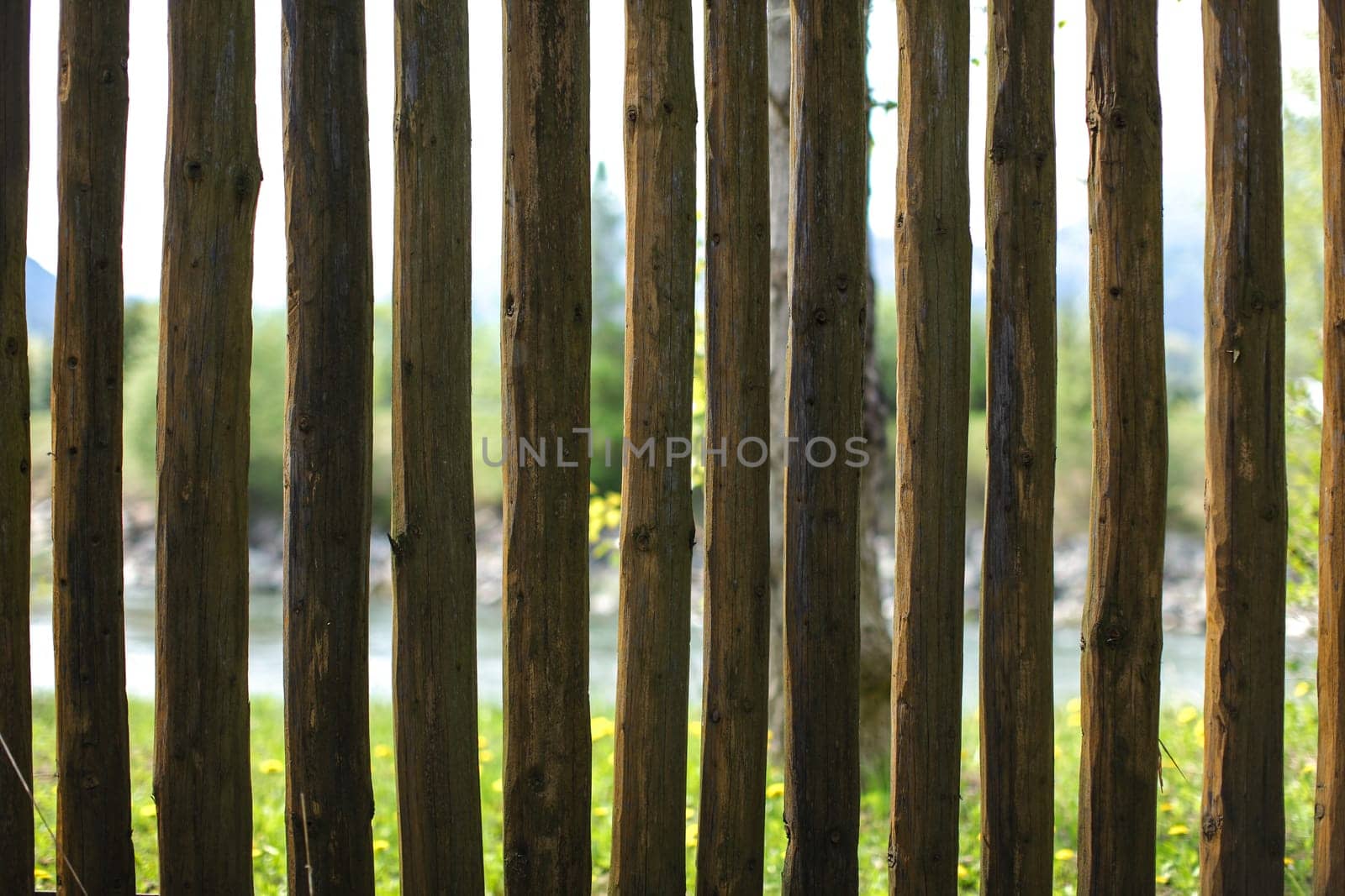 Old wooden fence posts, with blurred river out of focus in background.