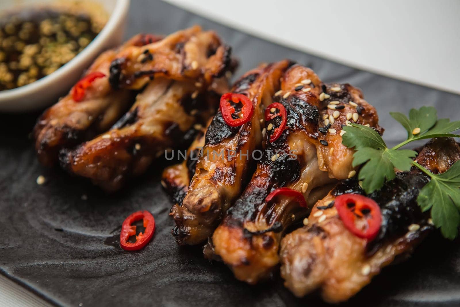 Hot organic chicken wings with red pepper on black dish