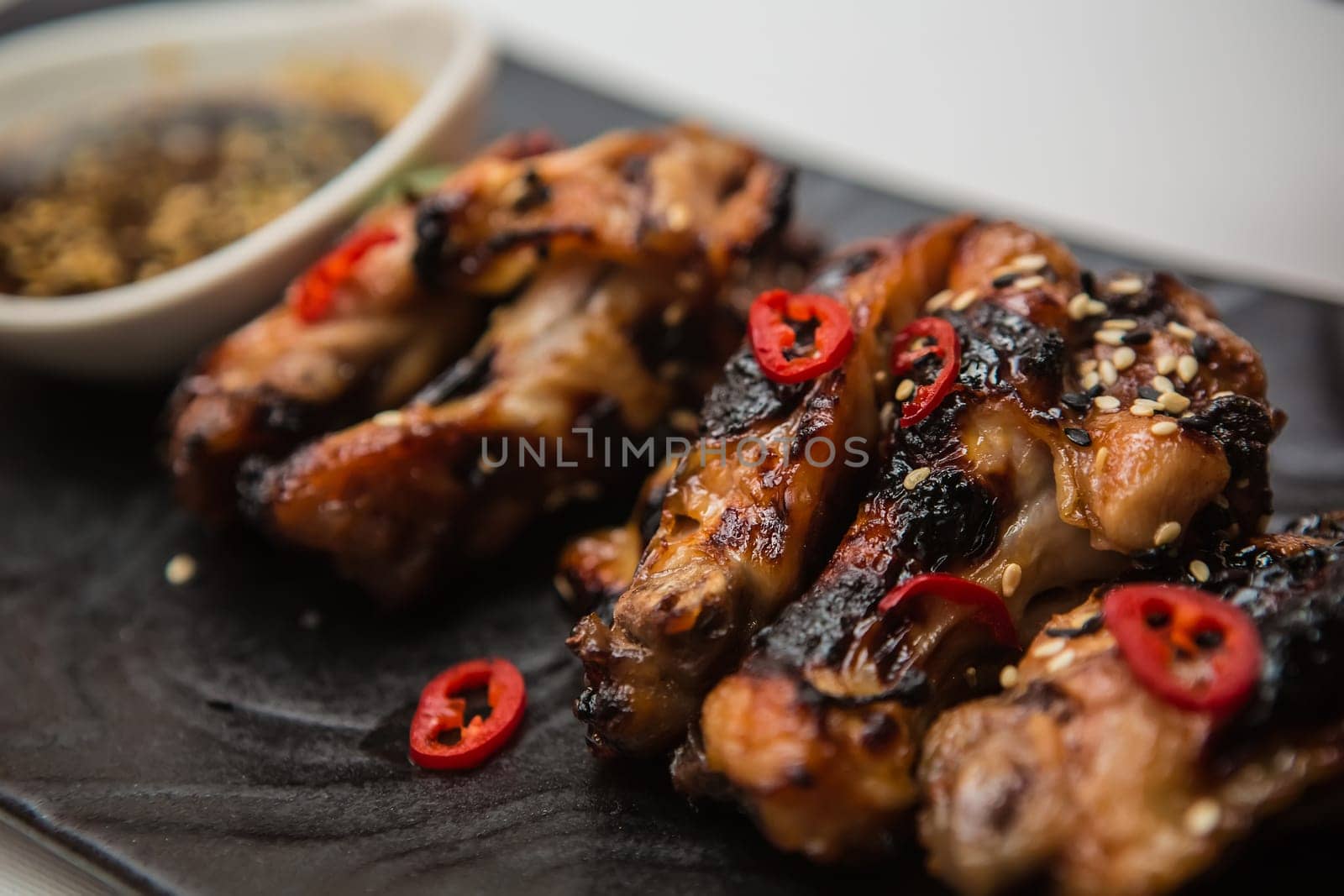 Hot organic chicken wings with red pepper on black dish