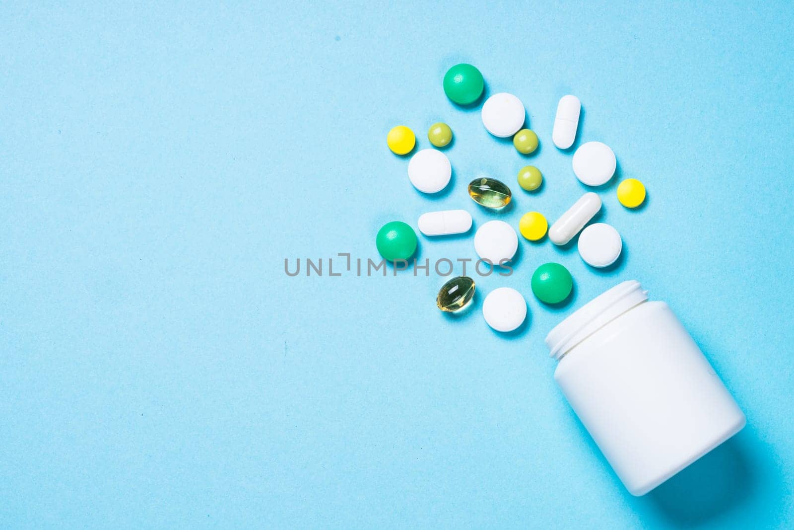 Pharmaceutical medical Pills, tablets and capsules on blue background top view. Medical pharmacy concept.