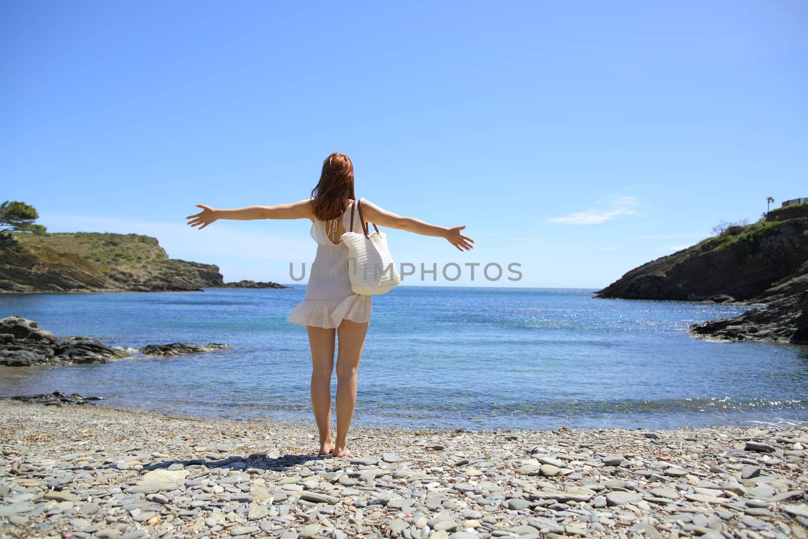 Woman stretching arms celebrating vacation on the beach