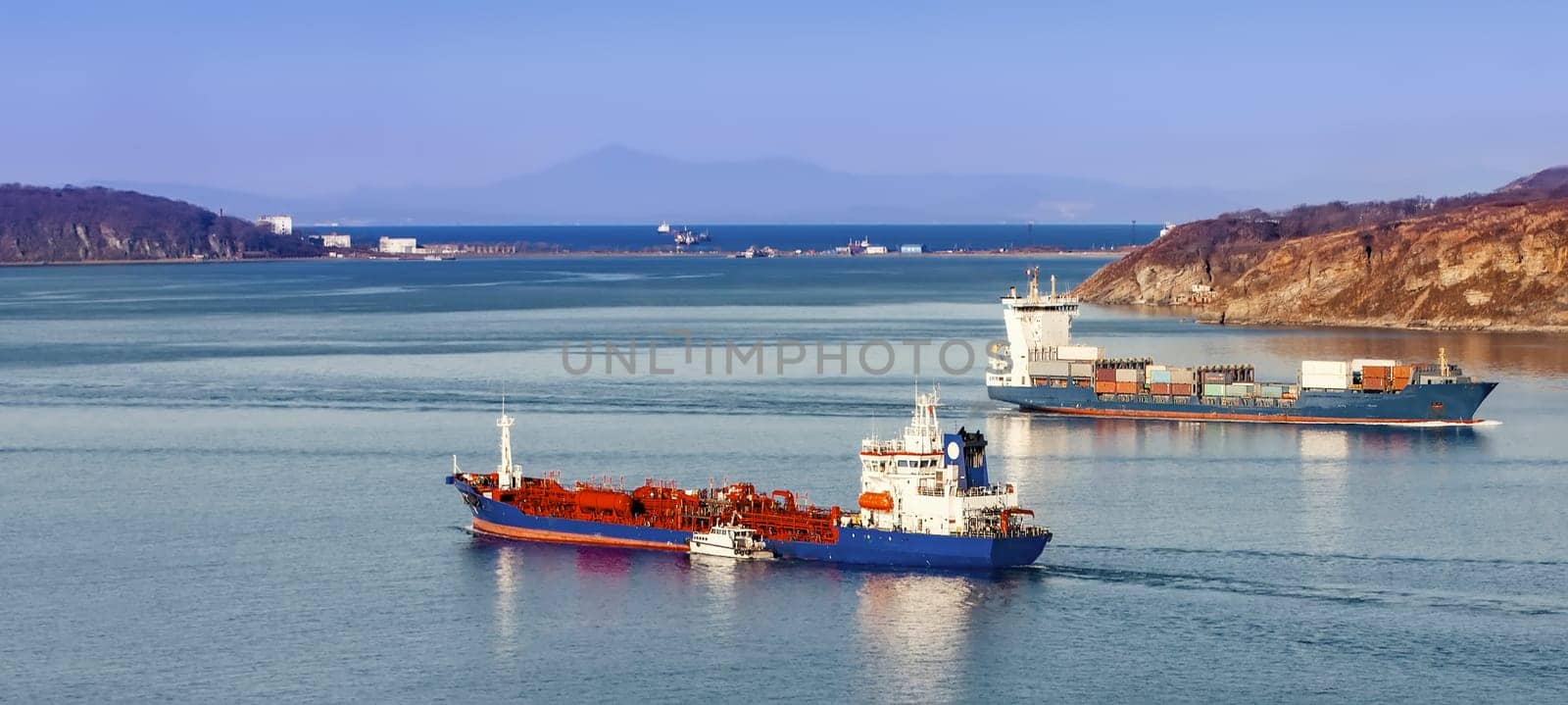 The Large container ship and reefer ship at blue sea. Selective focus
