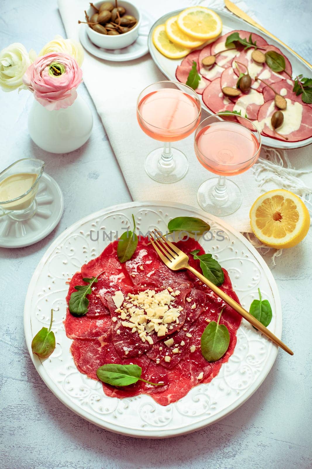 Appetizers - Vitello tonnato and beef Carpaccio with two glasses of rose wine.