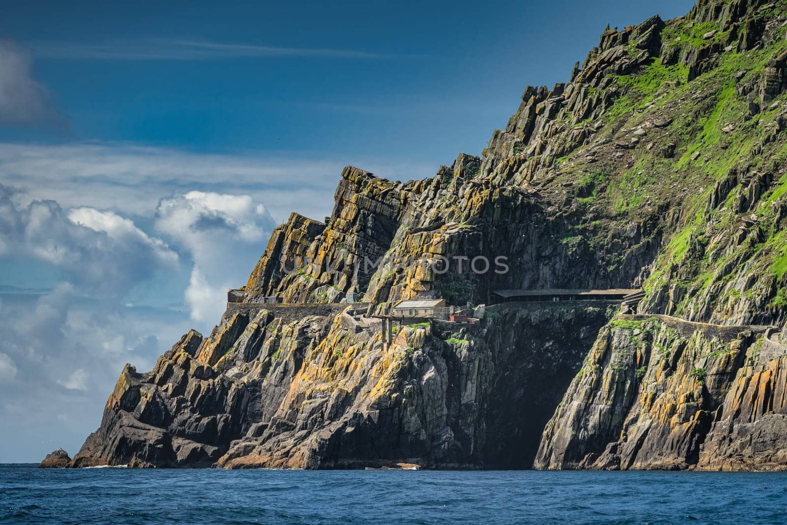 Helipad and shelter houses on the edge of cliff of Skellig Michael island, where Star Wars were filmed, UNESCO World Heritage, Ring of Kerry, Ireland