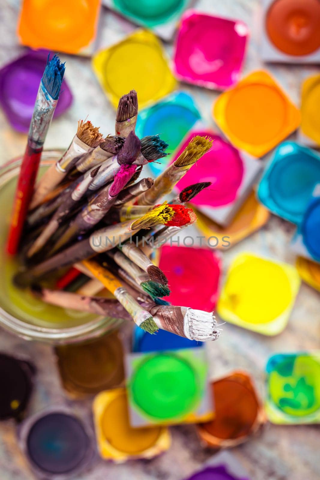 Set of colorful watercolor paints and paintbrushes for painting closeup. Selective focus.
