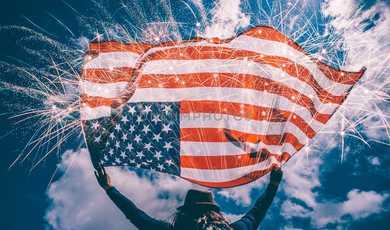 Young happy patriot girl holding the american flag under the 4th of July under fireworks.
