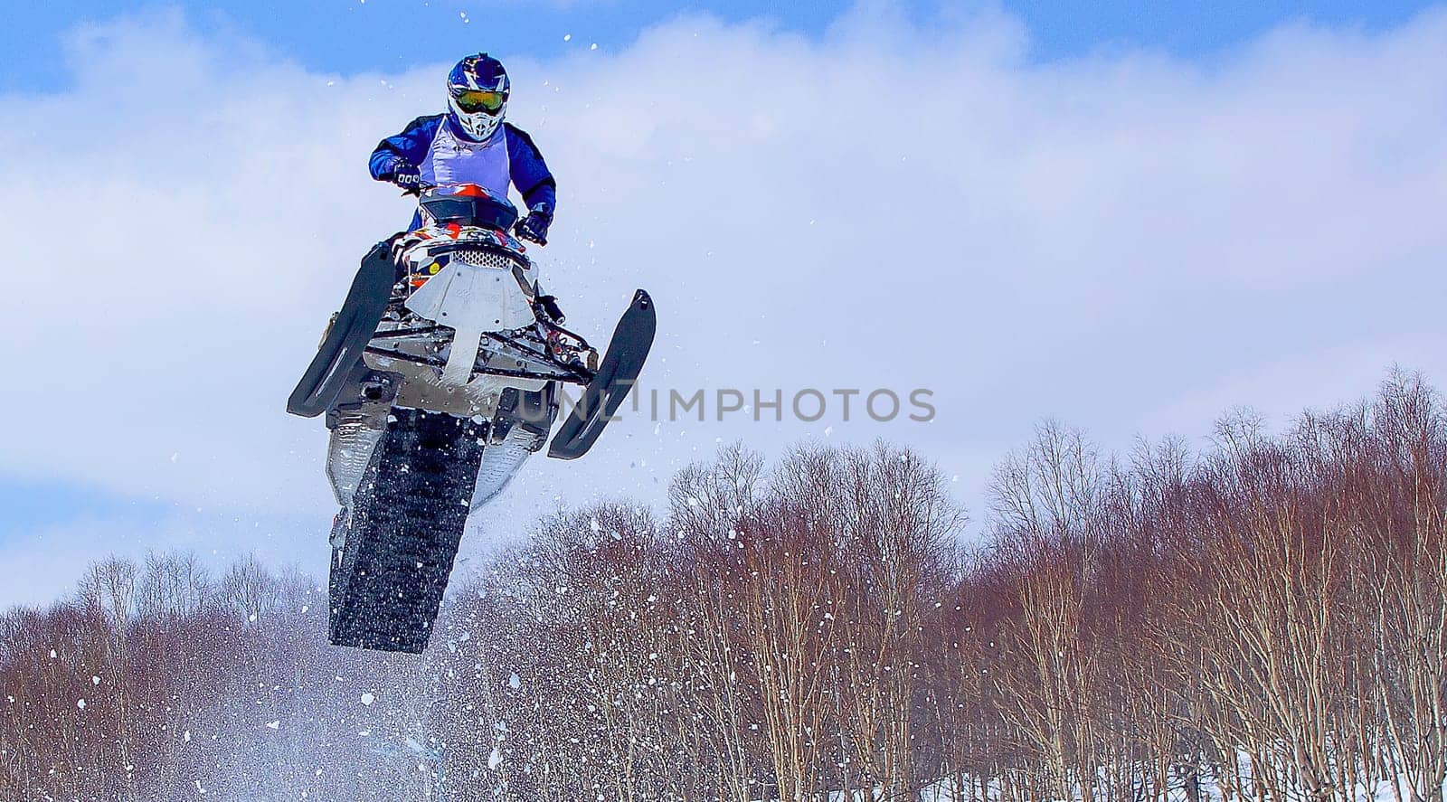 The Snowmobile in high jump above track. Selective focus