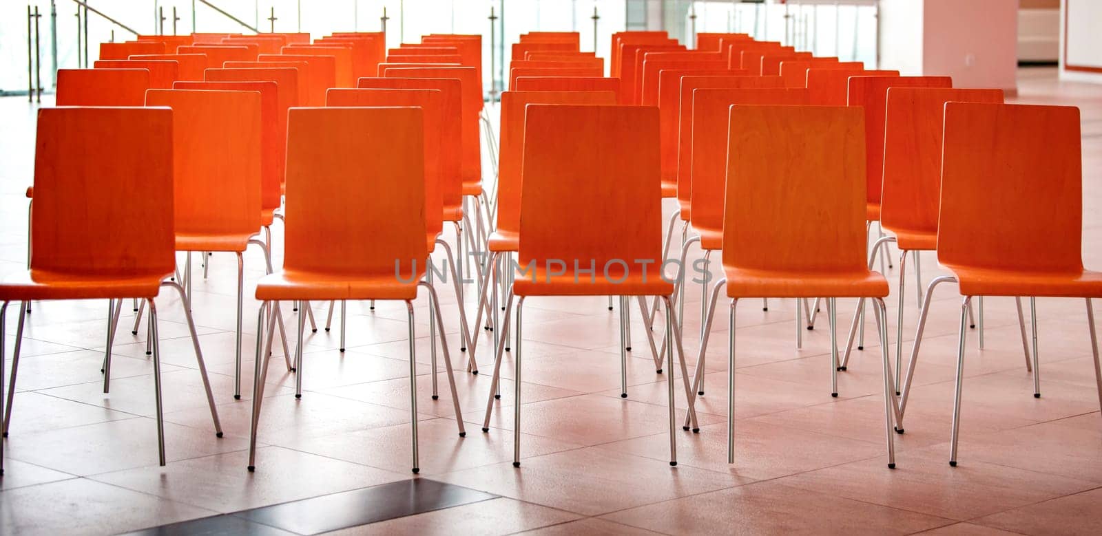 The Conference room with red chairs, concrete floor and windows. Selective focus