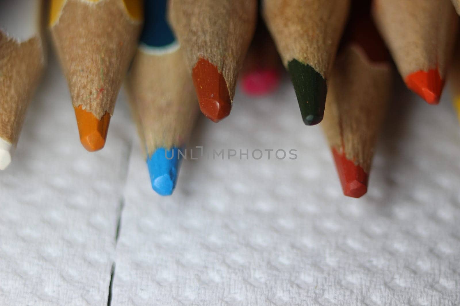 Close-up view of bright colored multicolor pencils on black background