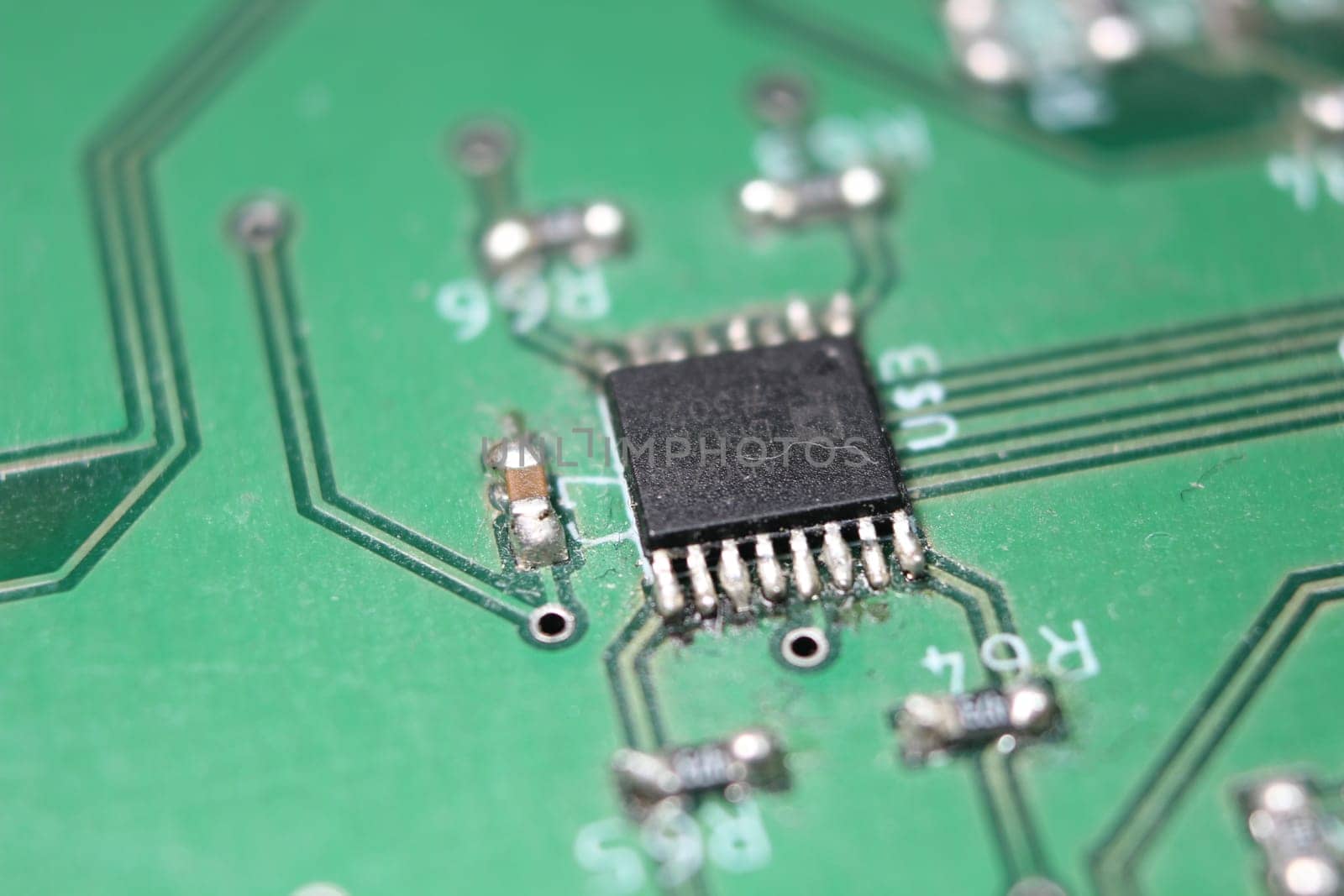 Electronic board with circuit lines and chip. Macro view of green board