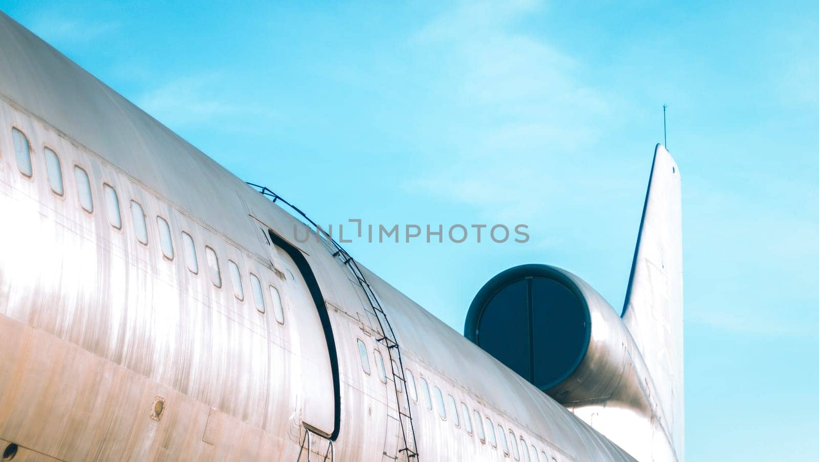 airplane exit door and window close up against blue sky