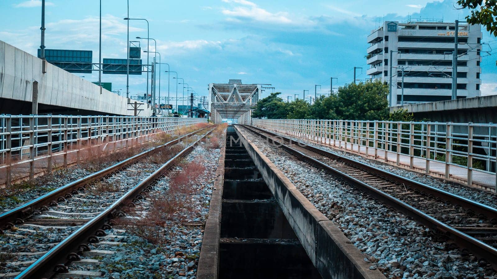Empty railway with no train and people, selective focus and vintage style. Railroad and beautiful sky at sunset in summer. Rural industrial landscape with railway station