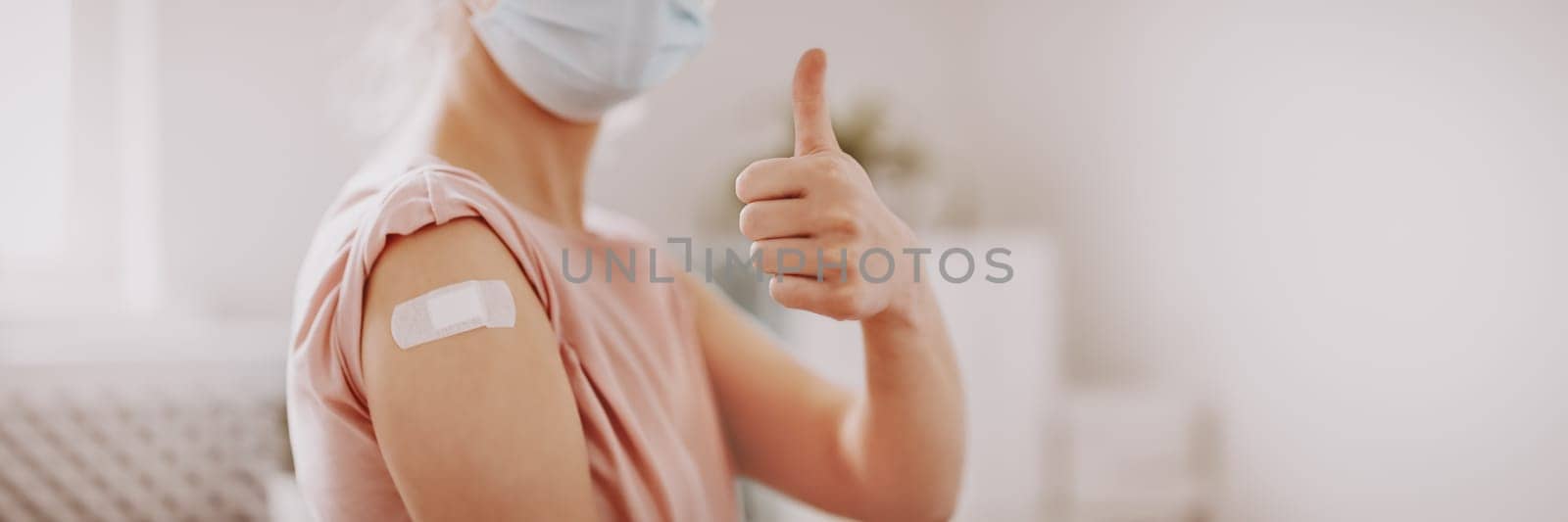 Woman showing thumb up after inoculation against Covid 19. Concept of immunization and making injections from pandemic of SARS.