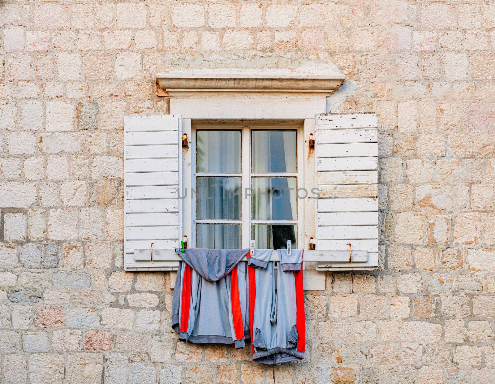 Window of old building in Montenegro, Europe. City architecture and details. Laundry hanging outside.