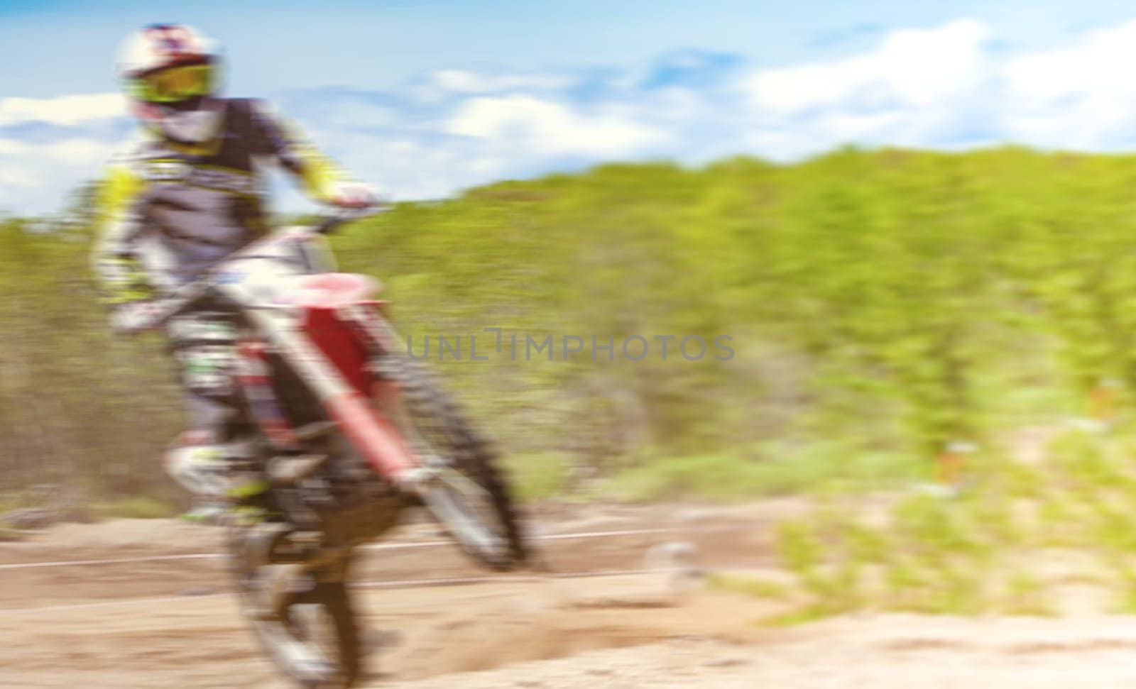 The Blurred Motocross riders practice tricks on their dirt bikes on a sunny day in Kamchatka