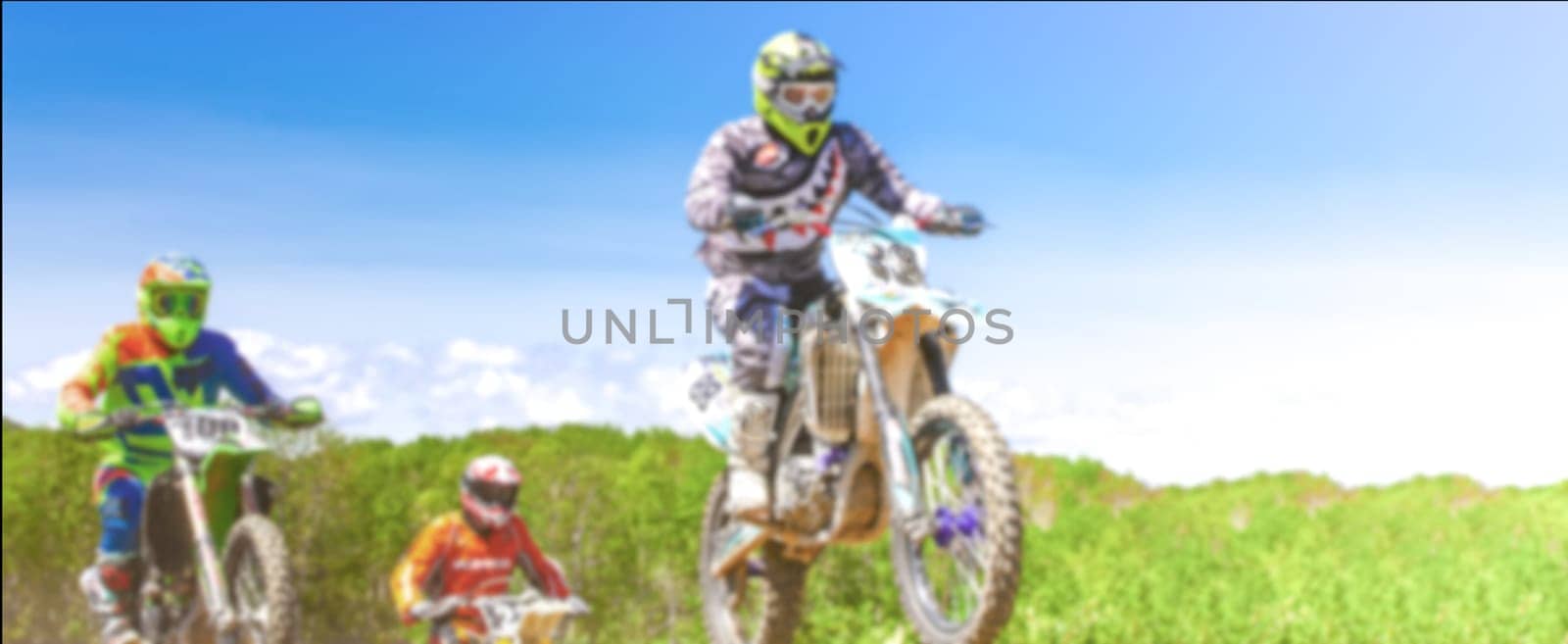 The Blurred Motocross riders practice tricks on their dirt bikes on a sunny day in Kamchatka