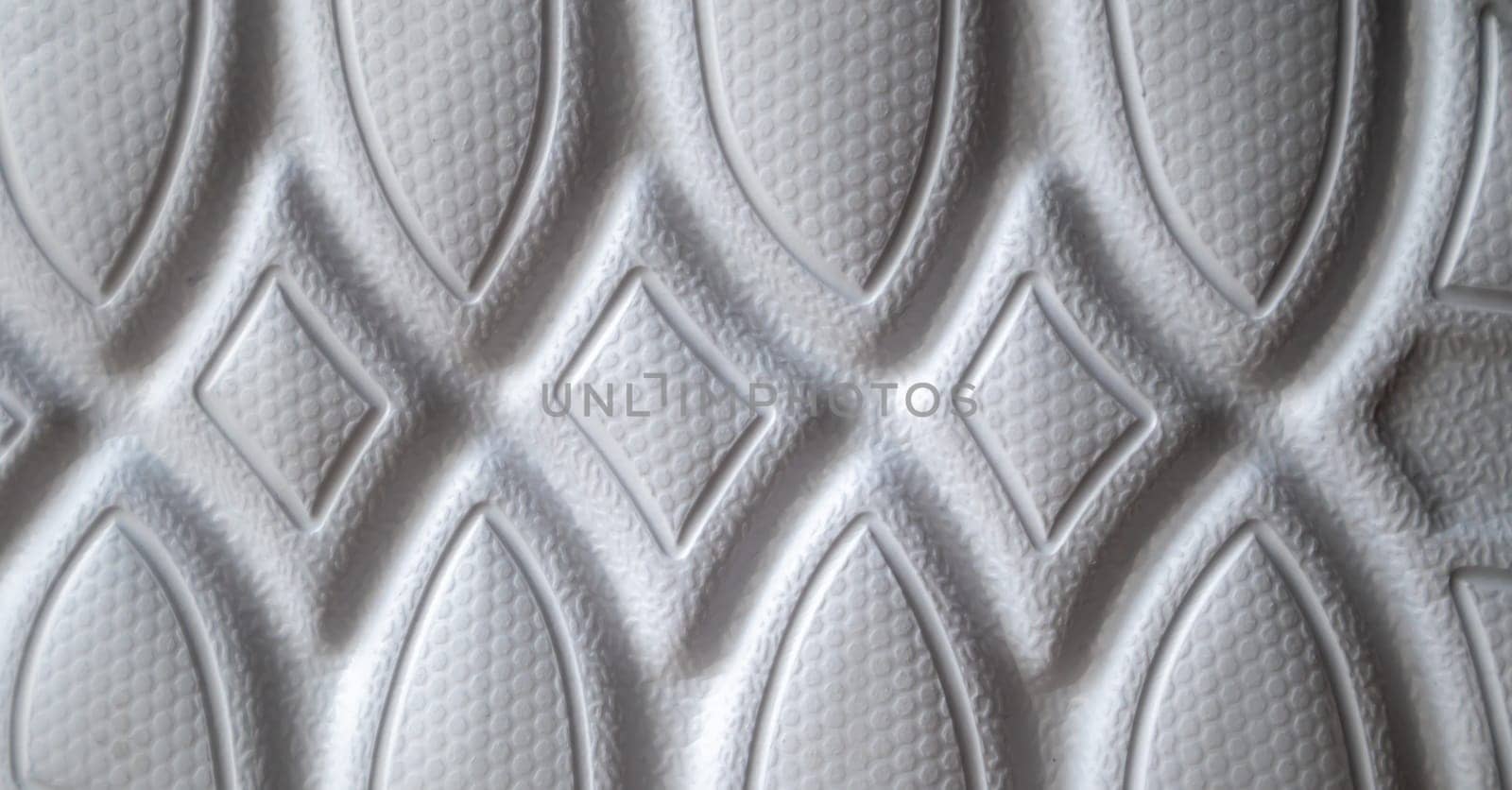 The outsole of new white sneakers. Rubber sole for men's shoes. Sole for sports and walking shoes. The texture of the material of sports shoes.