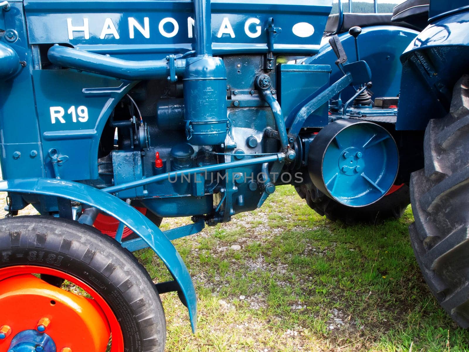 Nesselwang, Germany - July 23, 2020: Side view of a blue perfectly restored HANOMAG tractor away from a veteran tractor.