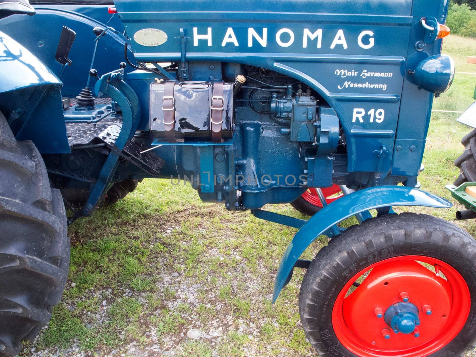 Nesselwang, Germany - July 23, 2020: Side view of a blue perfectly restored HANOMAG tractor away from a veteran tractor.