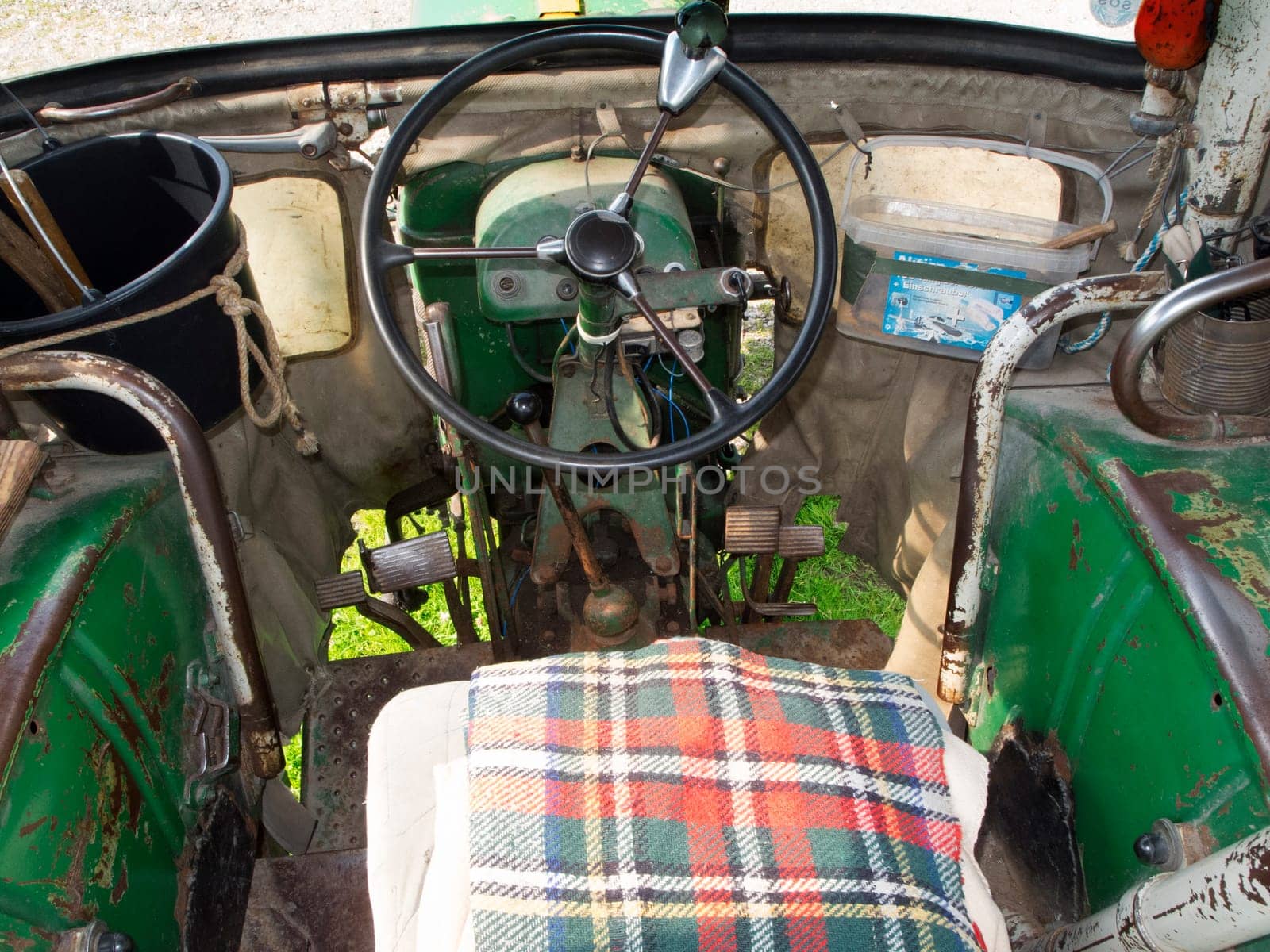 Nesselwang, Germany - July 23, 2020: Interior view with a view through the windshield of a green restored Deutz tractor aside from a veteran tractor.