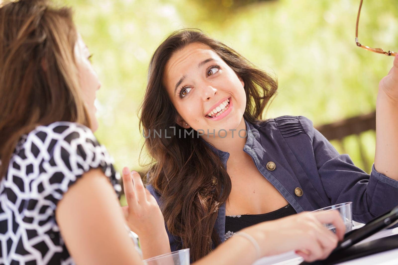 Expressive Young Adult Girlfriends Using Their Computer Electronics Outdoors