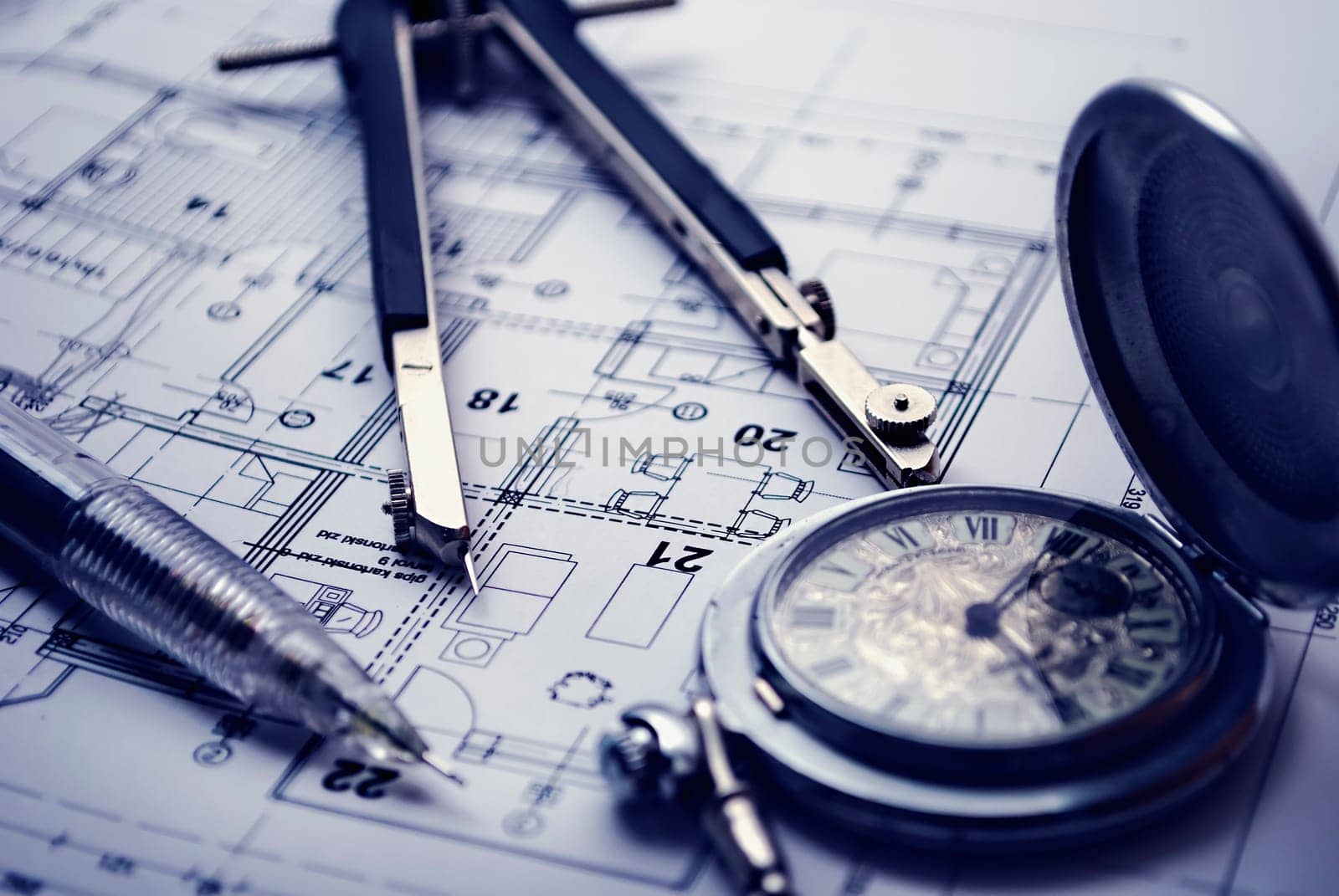 Dividers, pan and pocket watch laying on the architectural project