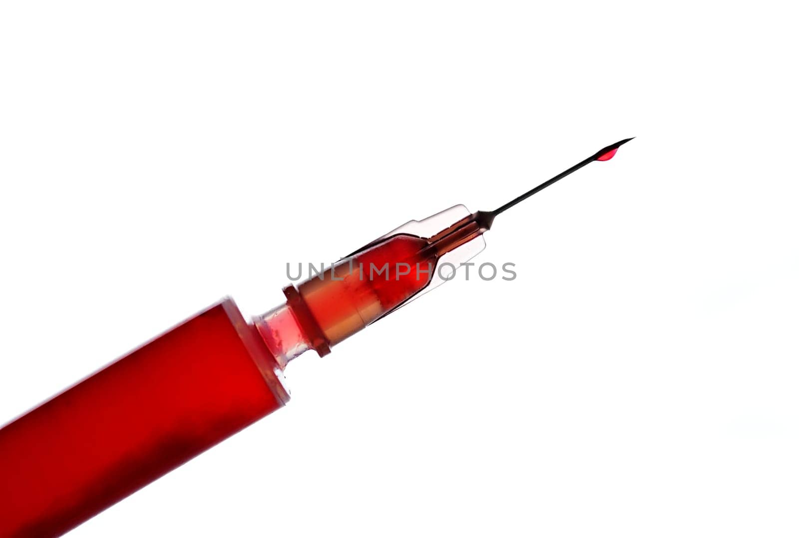 Syringe with red liquid isolated on white
