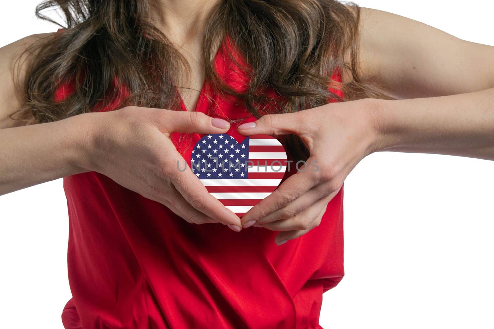 Love United States. The woman holds a heart in the form of the flag of United States on her chest. Concept of patriotism.
