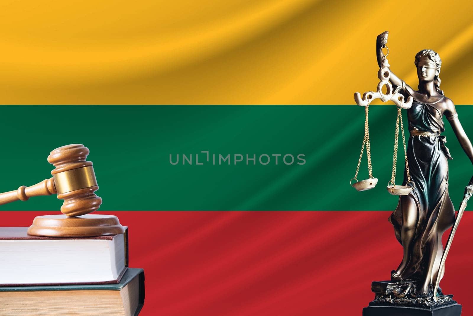 Law and justice in Lithuania. Statue of themis and the gavel of the judge against the background of the flag of Lithuania. Law and justice concept.
