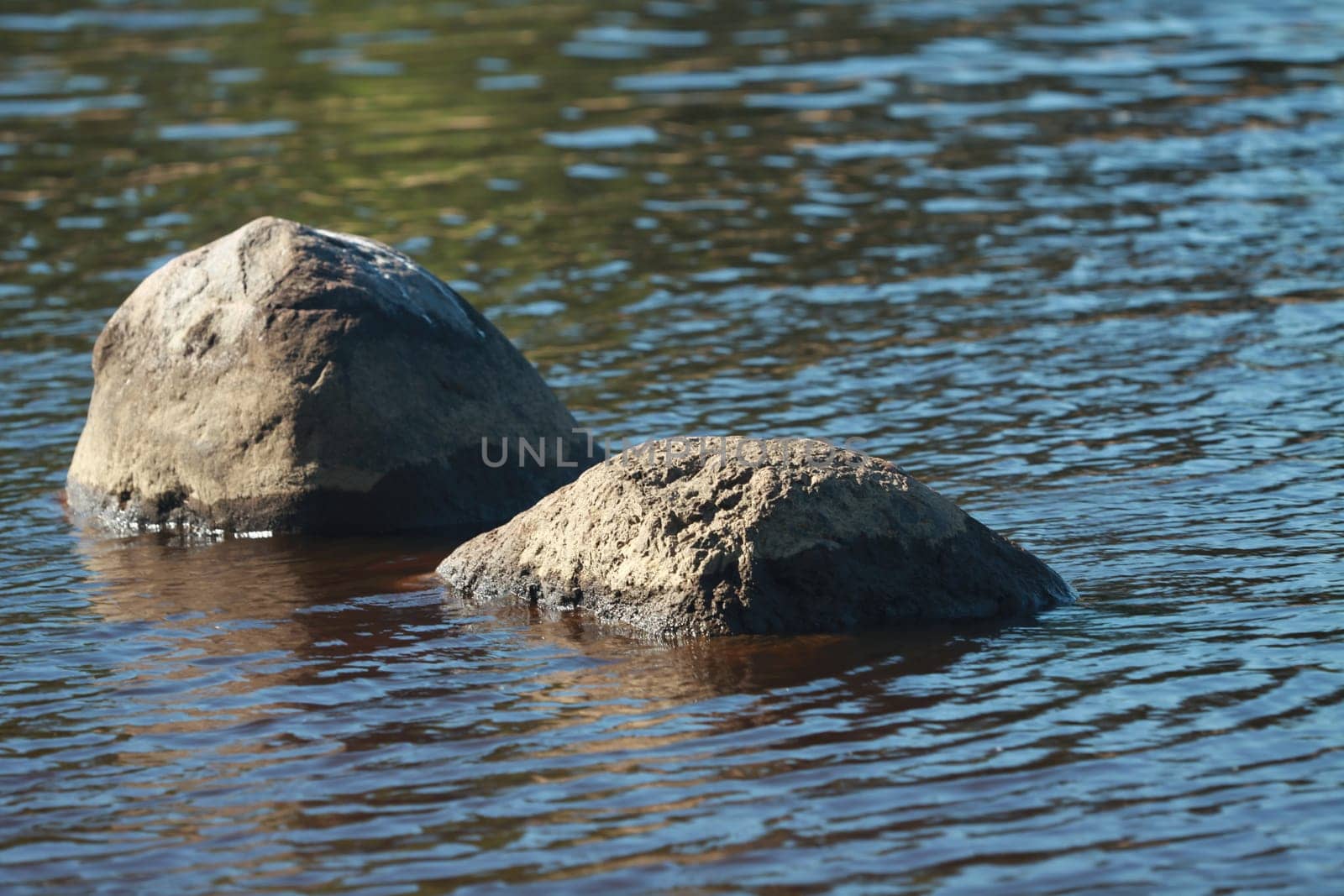 river landscape with granite boulders in blue water