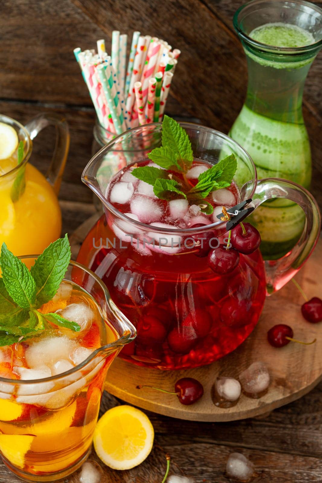 Ice cold beverages with fresh fruits in glass pitchers