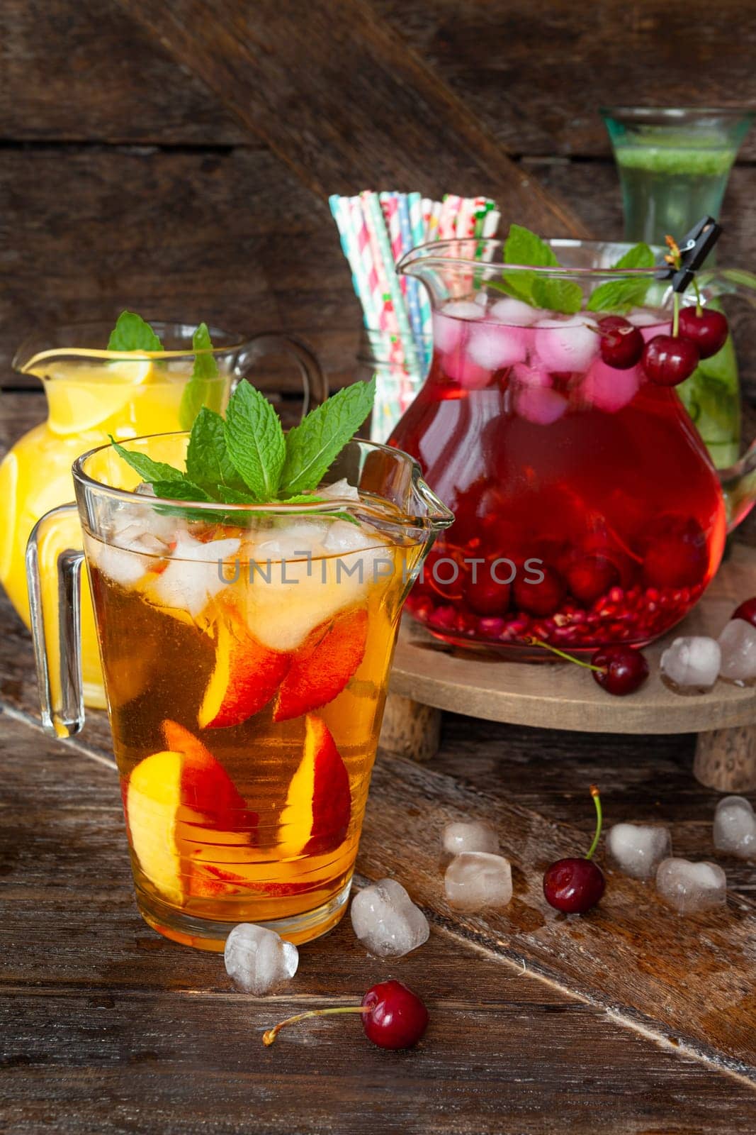 Ice cold beverages with fresh fruits in glass pitchers