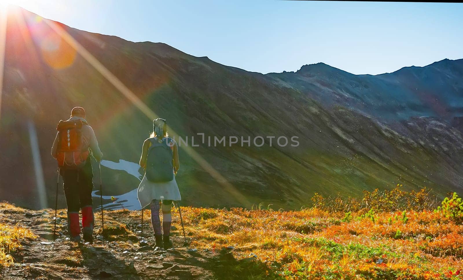 The selective focus two hikers in the mountains in the sun