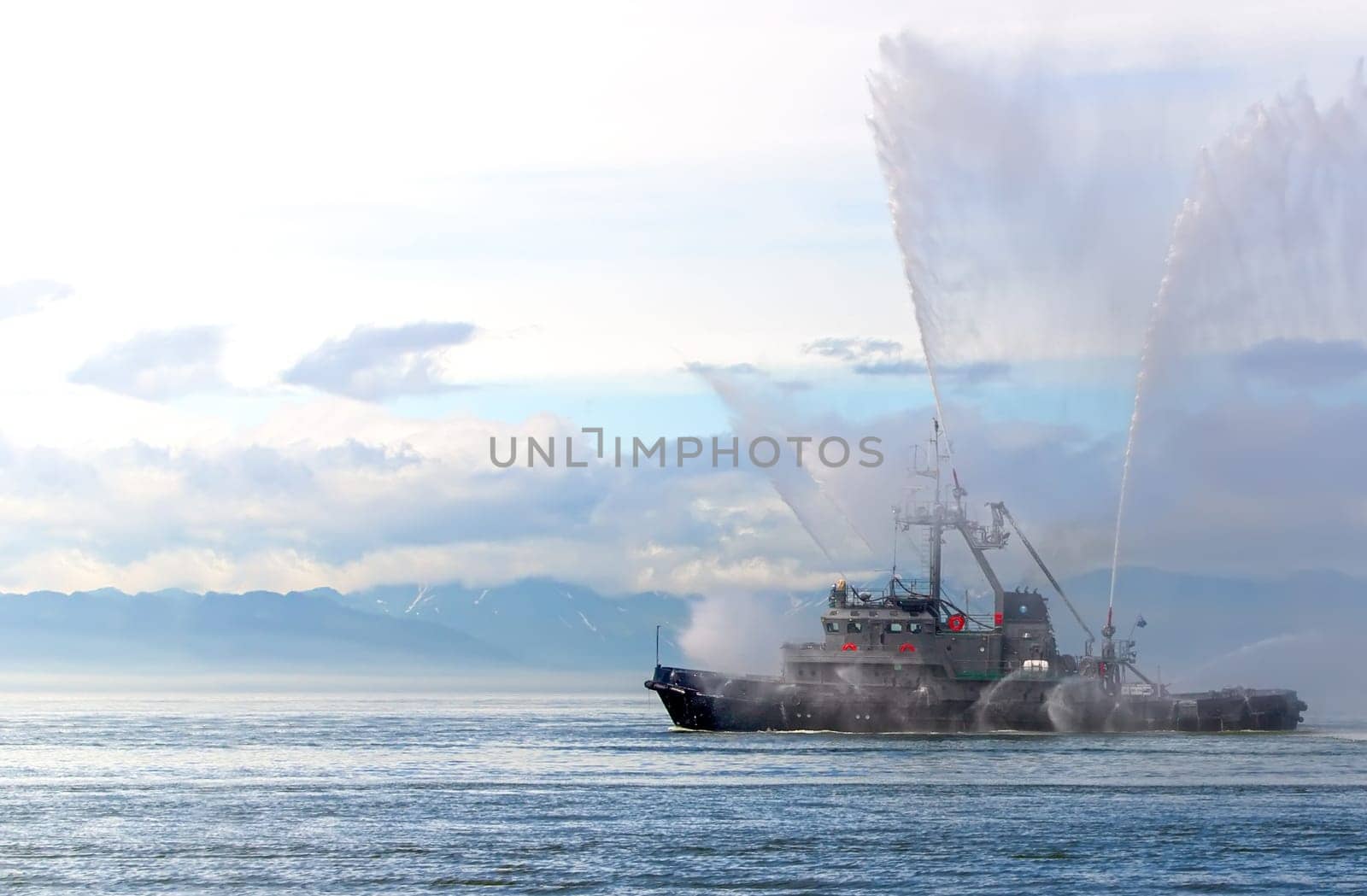 the Floating tug boat is spraying jets of water