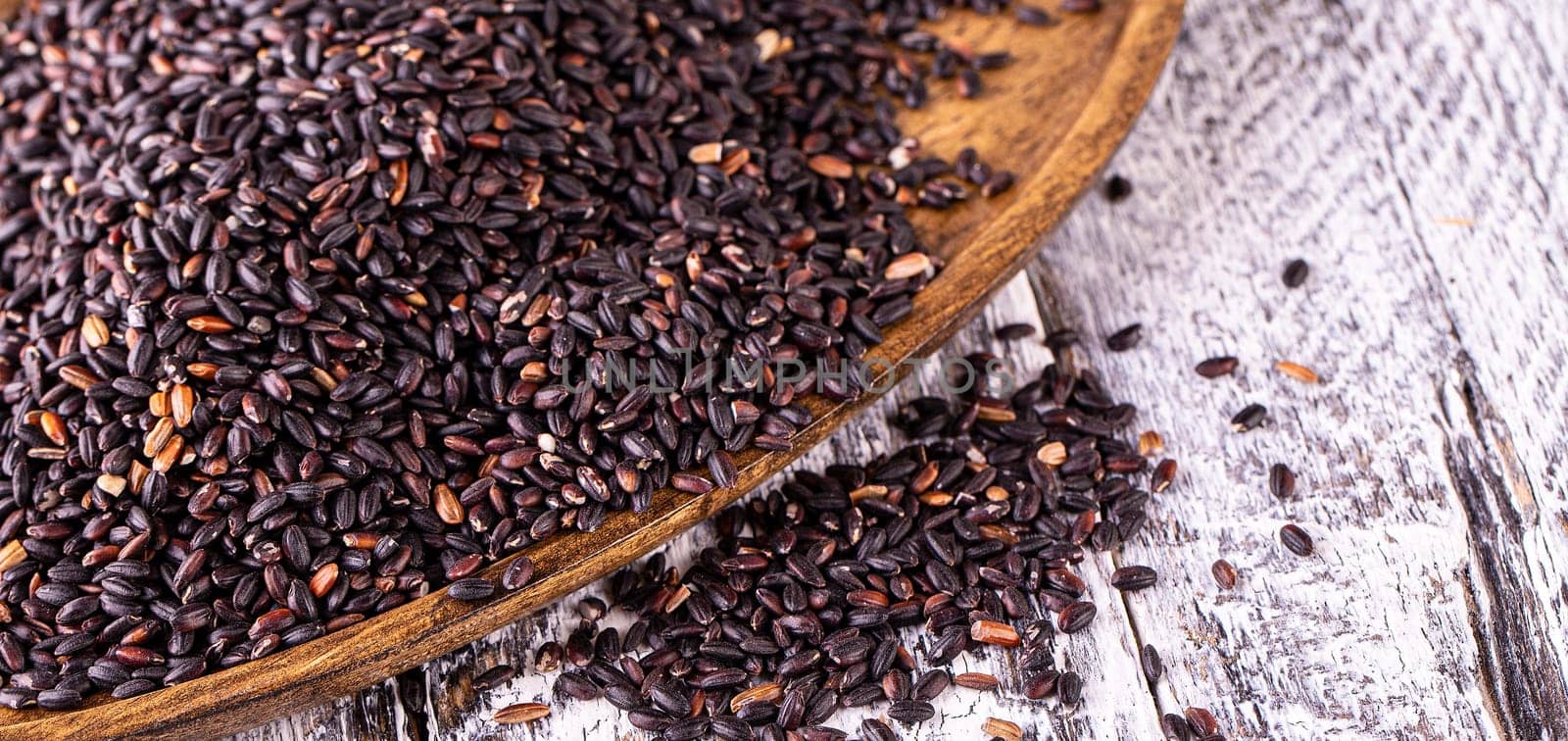 The black rice on old wooden table